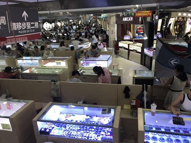 A busy aisle in a Chinese wholesale market with watches on display