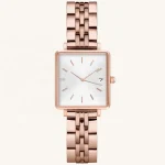 Rose gold square watch with a sleek metal strap, minimalist white dial, and date display, showcasing luxury and elegance.