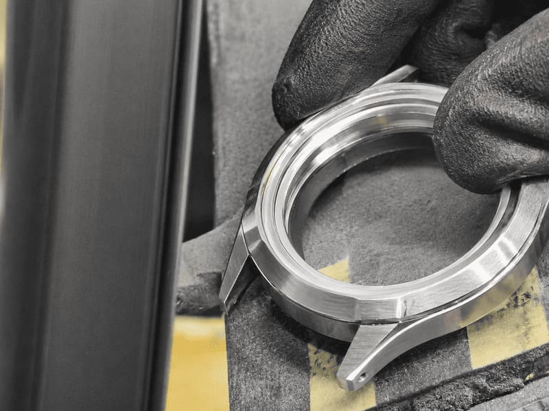 An industrial machine crafting a high-end watch case